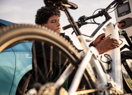 Young person charging the battery of an electric bicycle